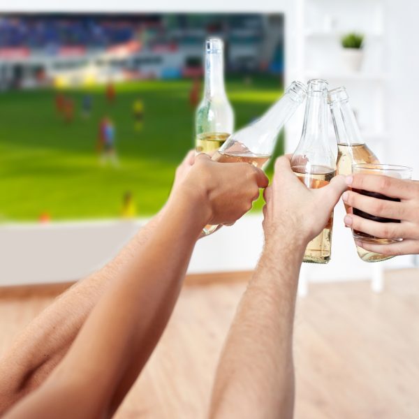 חברים צופים על מסך ענק במשחק כדורגל